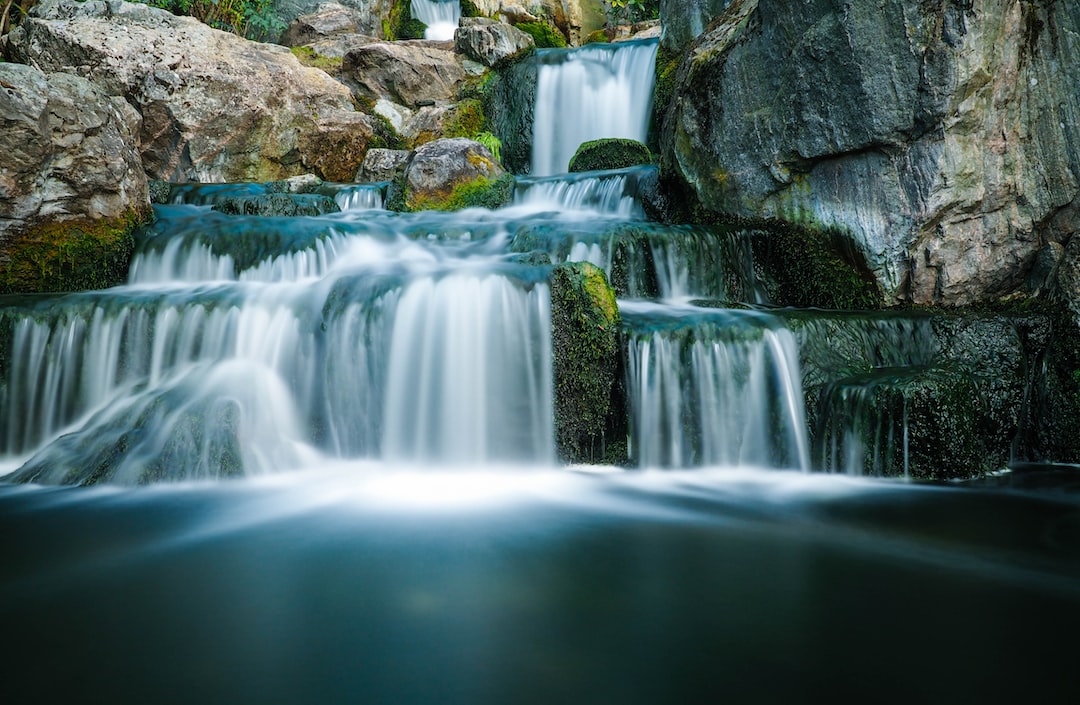 An image capturing the captivating Cachoeira Na Trilha Dos Macacos, where emerald waters cascade down moss-covered rocks, surrounded by a vibrant rainforest teeming with exotic flora and fauna