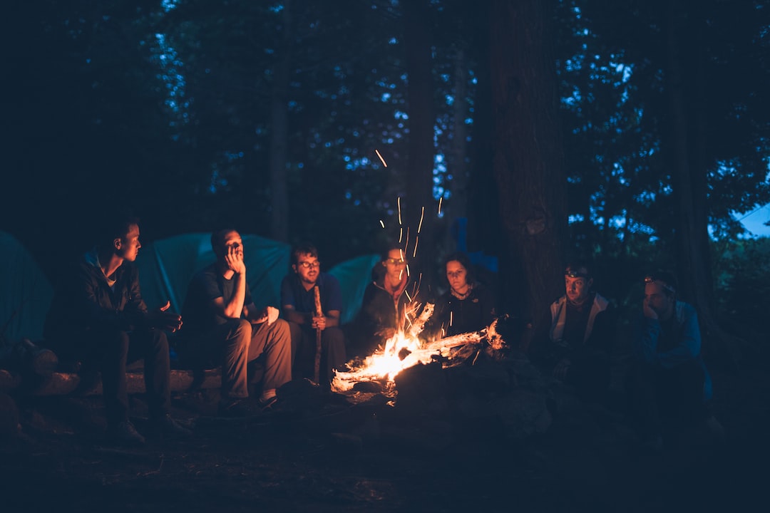 An image showcasing a fully equipped camping tent nestled amidst a serene forest landscape at dusk