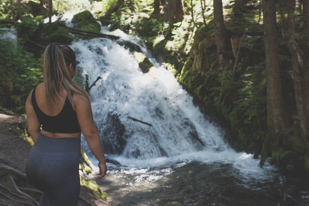 An image capturing the mesmerizing Cachoeira Da Fumaça Trail: dense emerald foliage draping over rugged cliffs, a majestic waterfall cascading into a crystal-clear pool below, and hikers immersed in the breathtaking natural beauty