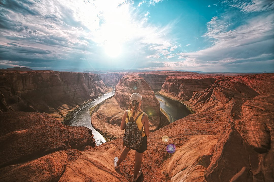 An image showcasing a traveler standing in front of an ancient, intricately carved monument, surrounded by vibrant historical landmarks