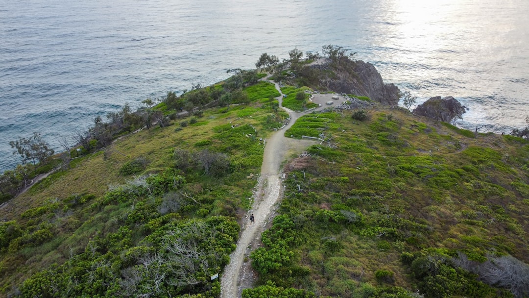 the essence of tranquility and charm on Trilha Praia Branca: a winding path through lush greenery, leading to a pristine white sand beach embraced by turquoise waters and framed by majestic cliffs